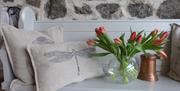 bench with dragonfly cushions and a vase of tulips