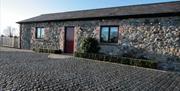 Image of a single story building with cobbles on the ground