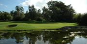 Water and woodland surrounding the green