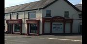A corner view of a guest inn by a roadside.