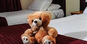 teddy bear sitting on double bed