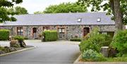 Image shows driveway up to the Granary, which is on the right of the image, with the loft (adjacent holiday home) to the left. Tree and bushes in fore