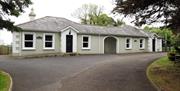 Image shows front of property with gravel driveway