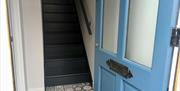 An opened front door leading to a staircase