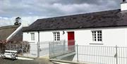 Outside of cottage with white exterior and red door