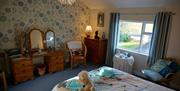 Image of a bedroom with a dressing table and patterned wallpaper