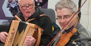 A man playing an accordion and a man playing a violin