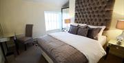 Image of a double bed with a padded headboard