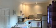 Image shows kitchen area with table and 2 chairs