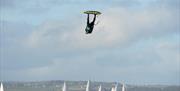 A kite surfer taking off into the air from the water