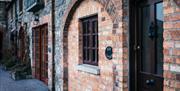 Image shows front door and brickwork of cottage