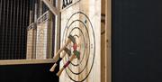 Axes stuck in a wooden target board.