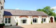 Image shows front of the property facing onto gravel drive/courtyard