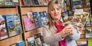 A photo of an Ards Visitor Information Centre staff member holding up tourist literature for the area