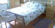 Double bed with bedside tables and baby moses basket