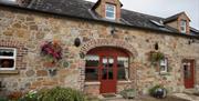 front door of cottage with stone walls