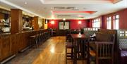 dining area with bar, bar stools, several tables and chairs