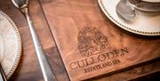 A dining setting showing a placemat with the Culloden logo