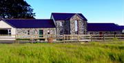 A full view of the cottages and spa from a long grassy field.