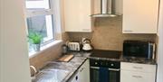 A small, fully fitted kitchen with a window