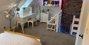 Image shows bedroom with dressing table and mirror, full length mirror and TV on wall