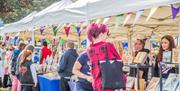 people browsing busy outdoor market stalls