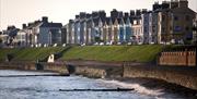 Ballyholme Esplanade during the day showing the waters splashing against the seawall.