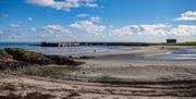 An image of Ballywalter harbour from the beach on a bright sunny day