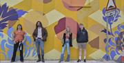 Banshee the overall winners from Buskfest 2024 pictured against street art in Banbridge.