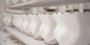 Pottery display - image of rows of pottery on wooden shelves.