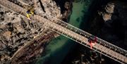 Birds eye perspective of people crossing over carrick-a-rede rope bridge