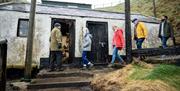 Tour group enters the old fisherman's cottage, an original building which still stands on the island