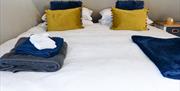 King sized bed with white linen and towels