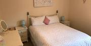 Image shows double bedroom with side tables and dressing table