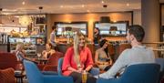 Couples sitting with drinks in a cafe and bar.