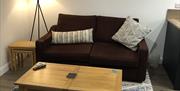 Living room with sofa, coffee table and lamp at The Heagry