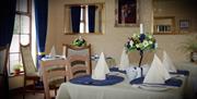 Image shows breakfast room with tables and chairs