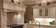 Modern kitchen with range cooker, cream cabinets and sink in the island