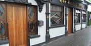 A white building with ornate black features and a wooden door