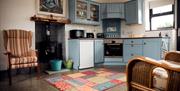 Kitchen area with stove and fireside seating