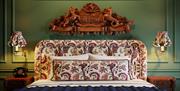 Close up of the bed with a floral headboard and the Slieve Donard crest above the bed.