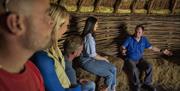 Group listens to stories told by Padraig Carragher inside a handwoven wooden glamping structure