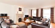 The Guest Lounge with 3 brown leather sofa's,  large coffee table, TV and gas fire,