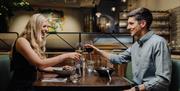 couple eating and drinking at dining table.