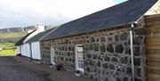 Rear exterior view of a stone cottage.