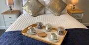 Image show breakfast tray on double bed in guest room