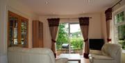 living area with sofas, TV and patio doors