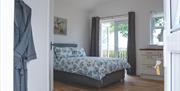 Double bedroom with patio doors leading to outside area