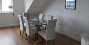 Dining area with glass table seated for six.