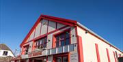 The exterior of the Rinkha building, painted red and white.